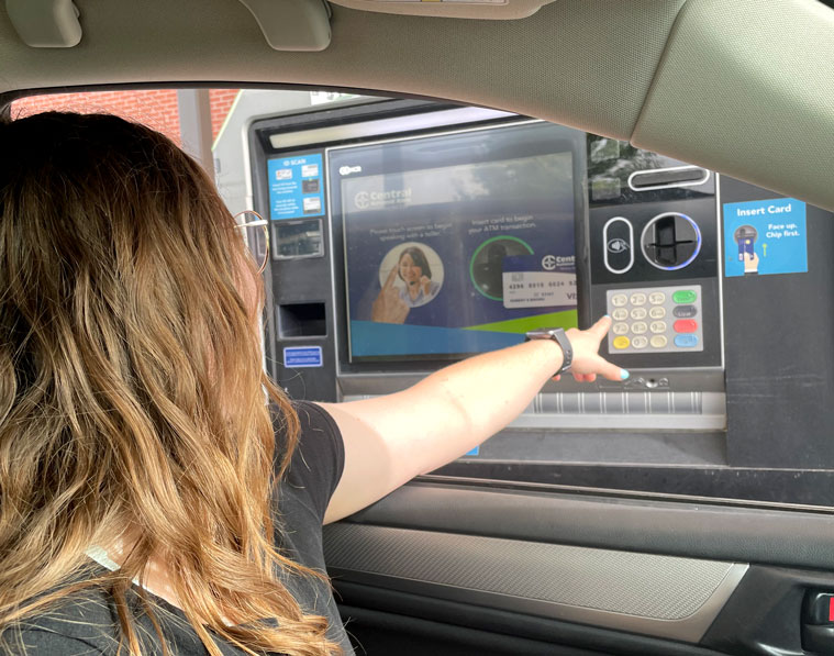 Person in car leaning out window to operate Interactive Teller Machine